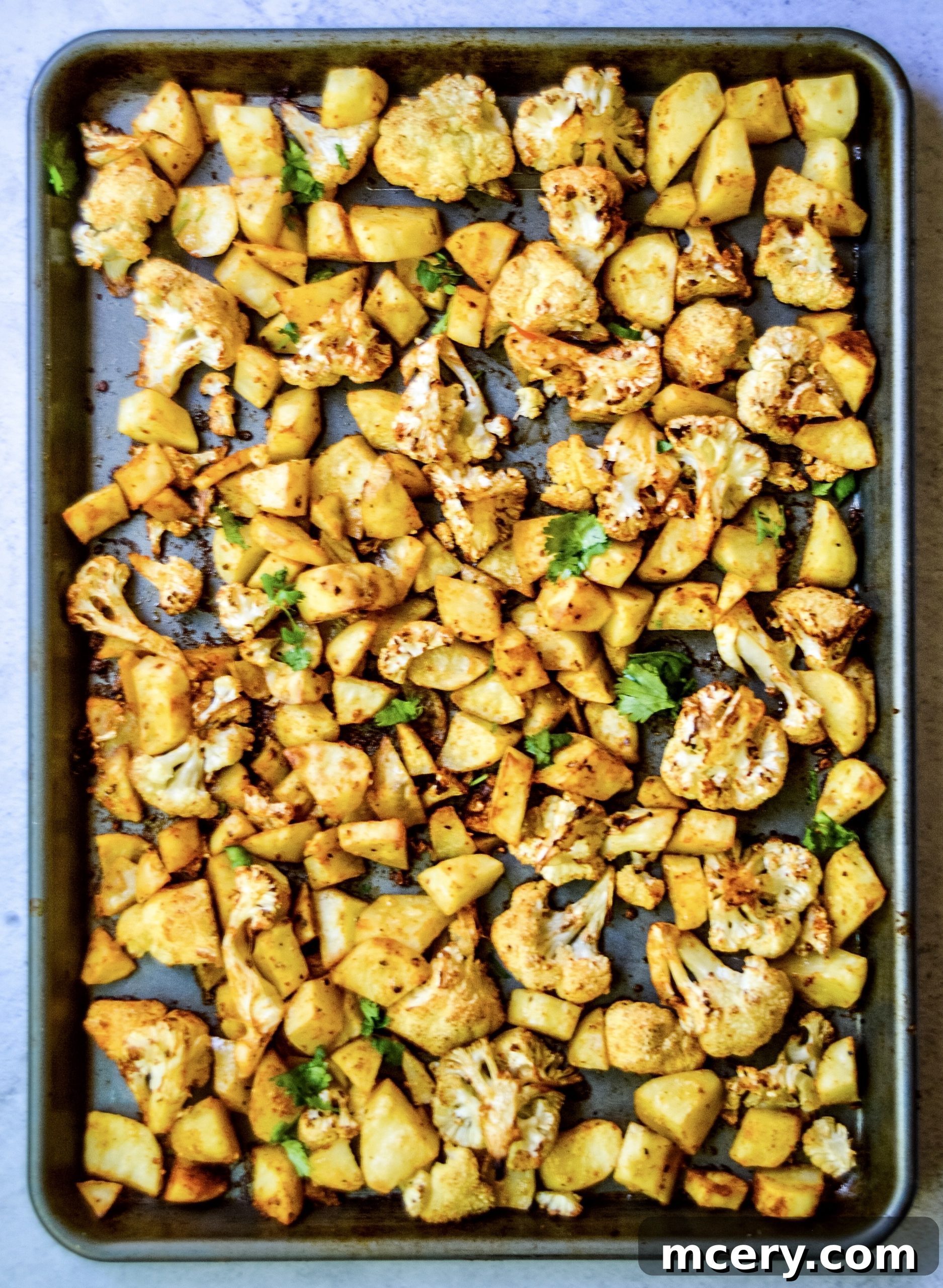 Taco Roasted Cauliflower and Potatoes with a Creamy Dip 3 Roasted cauliflower and potatoes seasoned with taco spices, arranged on a baking sheet, ready for serving or plating into a meal.