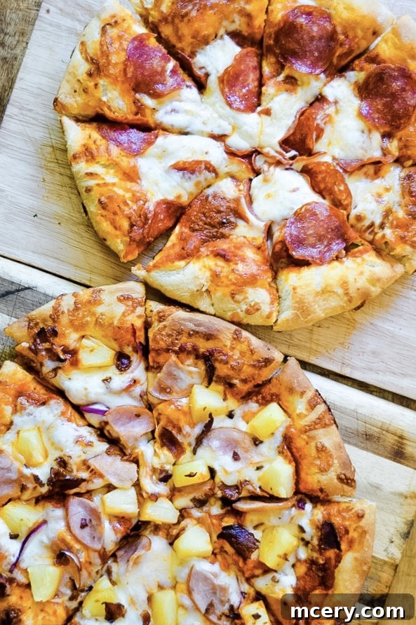 Fast and Easy Food Processor Pizza Dough 3 Hands gently kneading pizza dough on a lightly floured wooden surface, showing its soft and pliable texture.