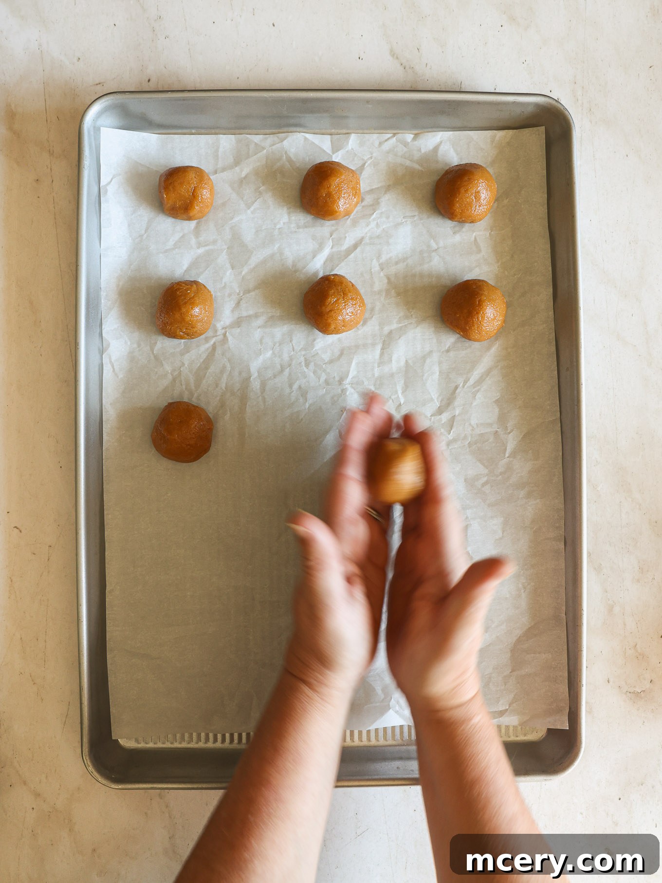 Effortless 4-Ingredient Peanut Butter Cookies 6 Evenly rolled cookie dough balls placed on a lined baking sheet, spaced for baking.