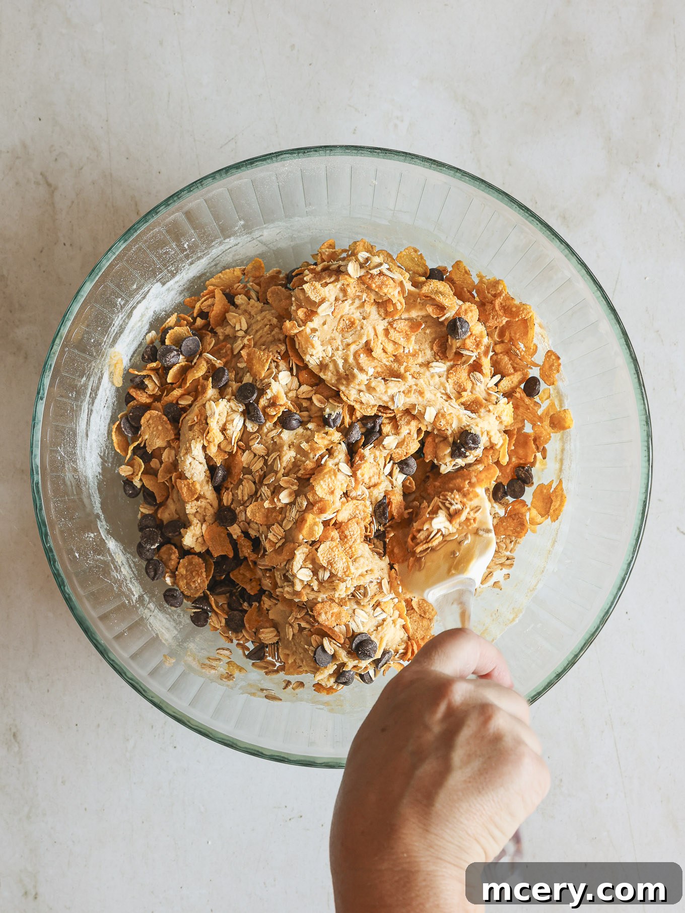 No-Bake Crispy Cornflake Treats 8 Cornflakes and chocolate chips folded into cookie dough, showing the texture and even distribution of mix-ins.