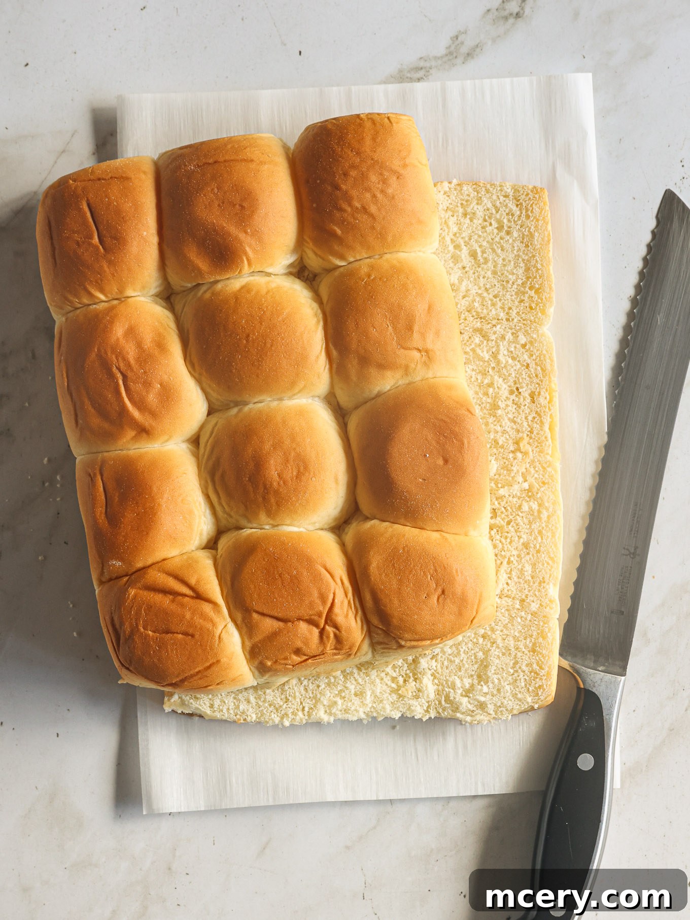 sliced hawaiian rolls on a cutting board.