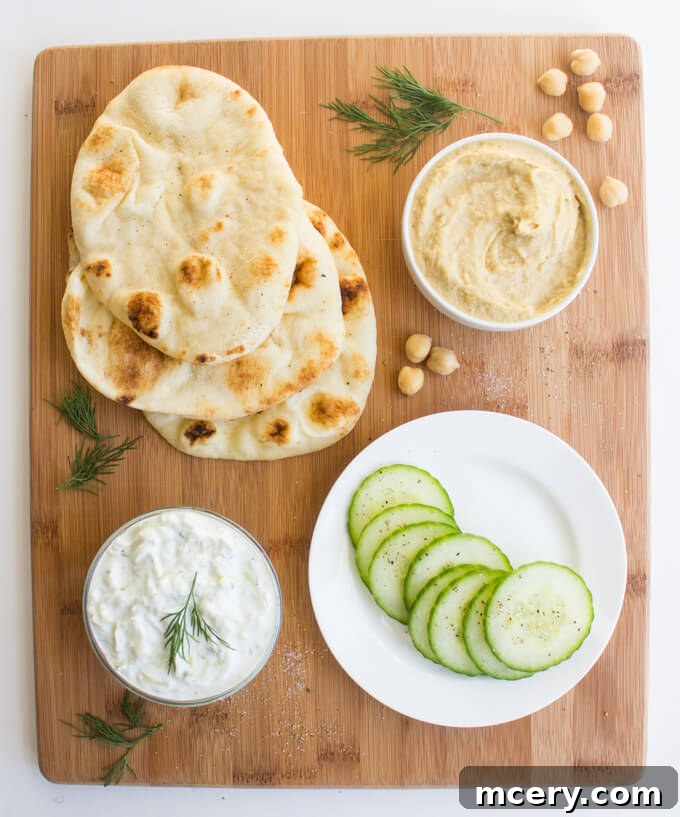Easy Hummus Naan Toasts: 3 Delicious Variations 4 A mini naan toast topped with creamy hummus, slices of fresh avocado, chopped roasted red pepper, and crumbled feta cheese.