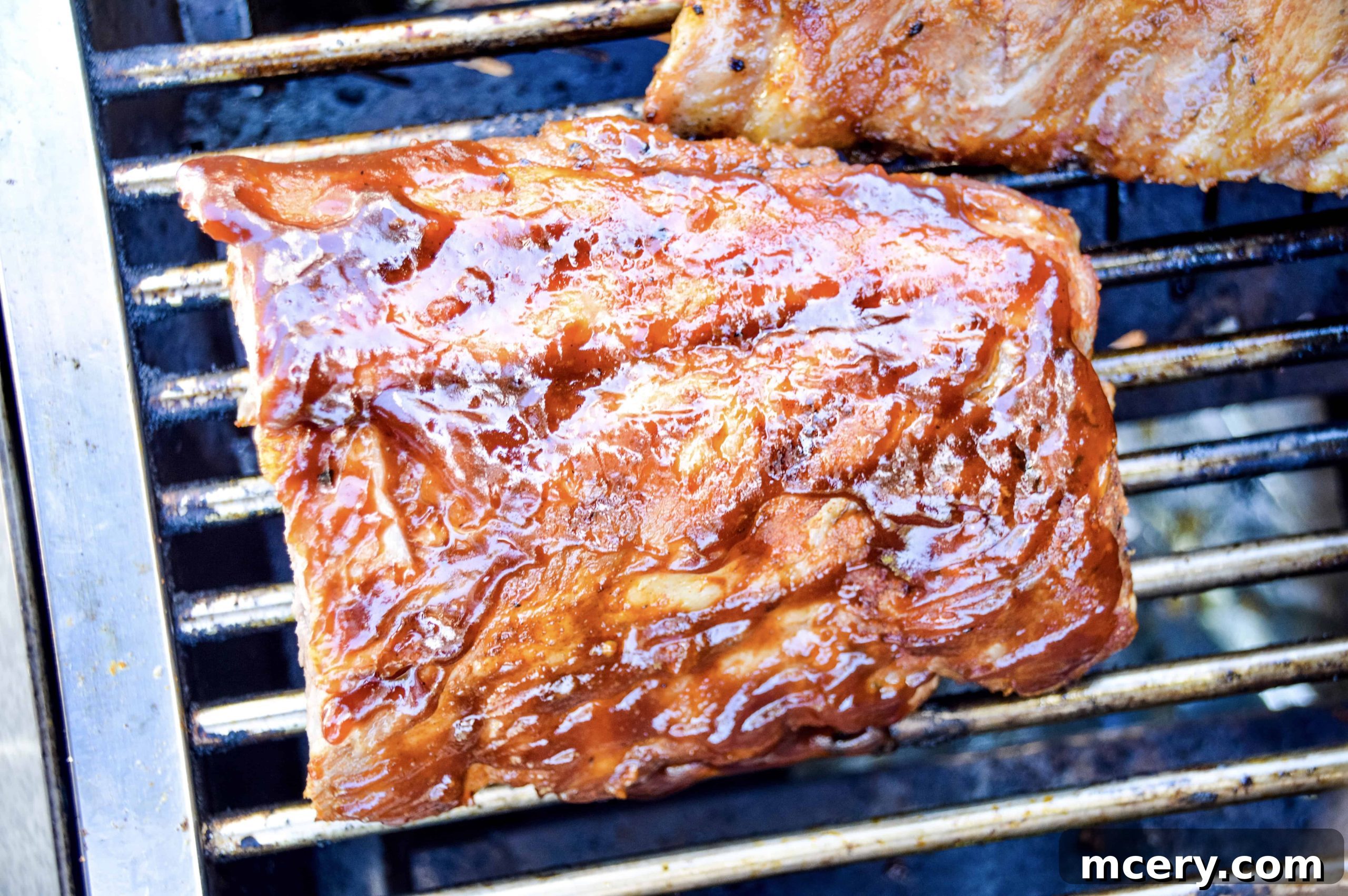 Paleo Rubbed Gas Grilled Pork Ribs 11 Grilled pork ribs on a serving platter, freshly sliced and ready to eat.