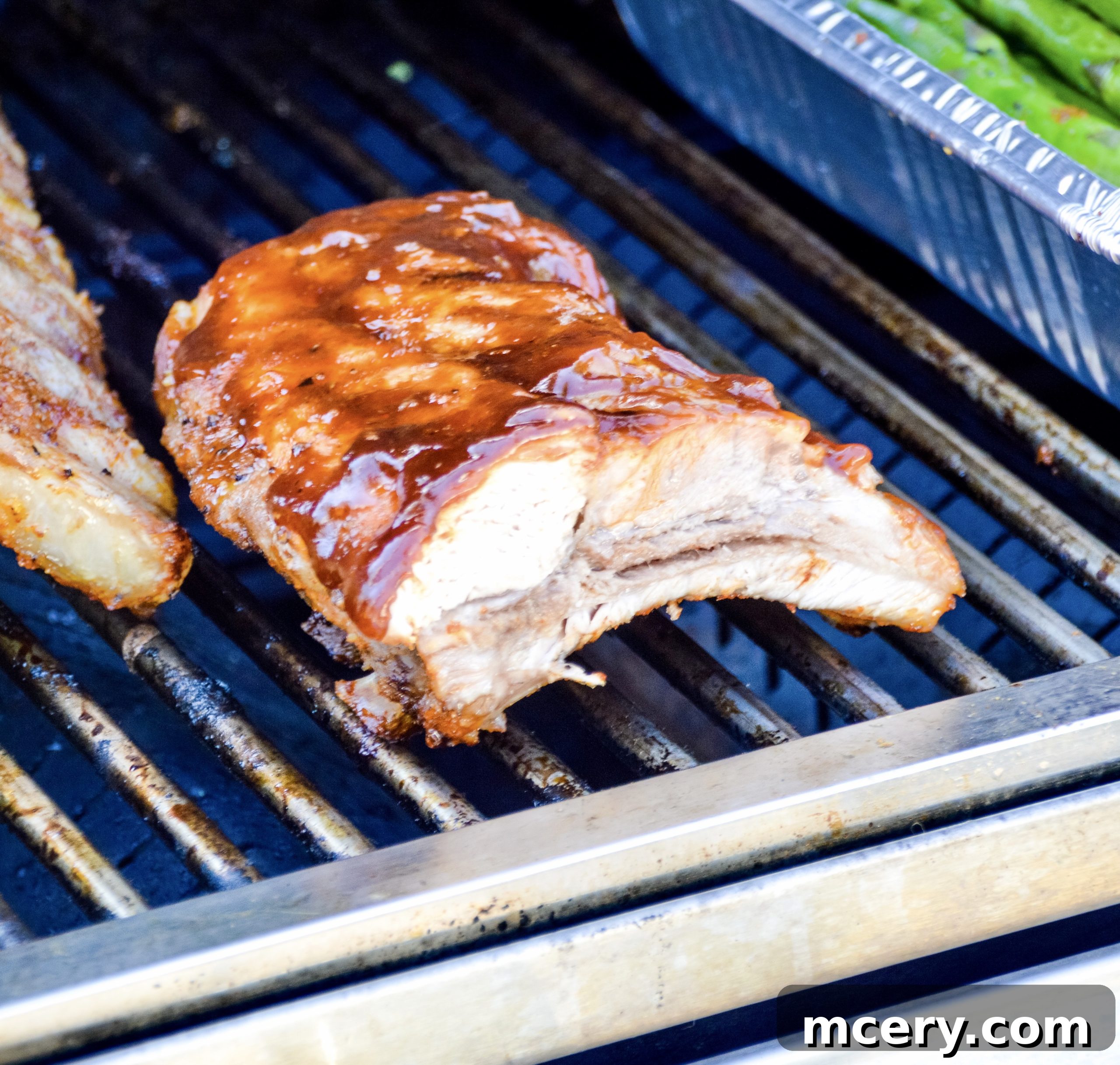 Paleo Rubbed Gas Grilled Pork Ribs 3 Close-up of seasoned raw pork ribs in an aluminum tray, ready for grilling.