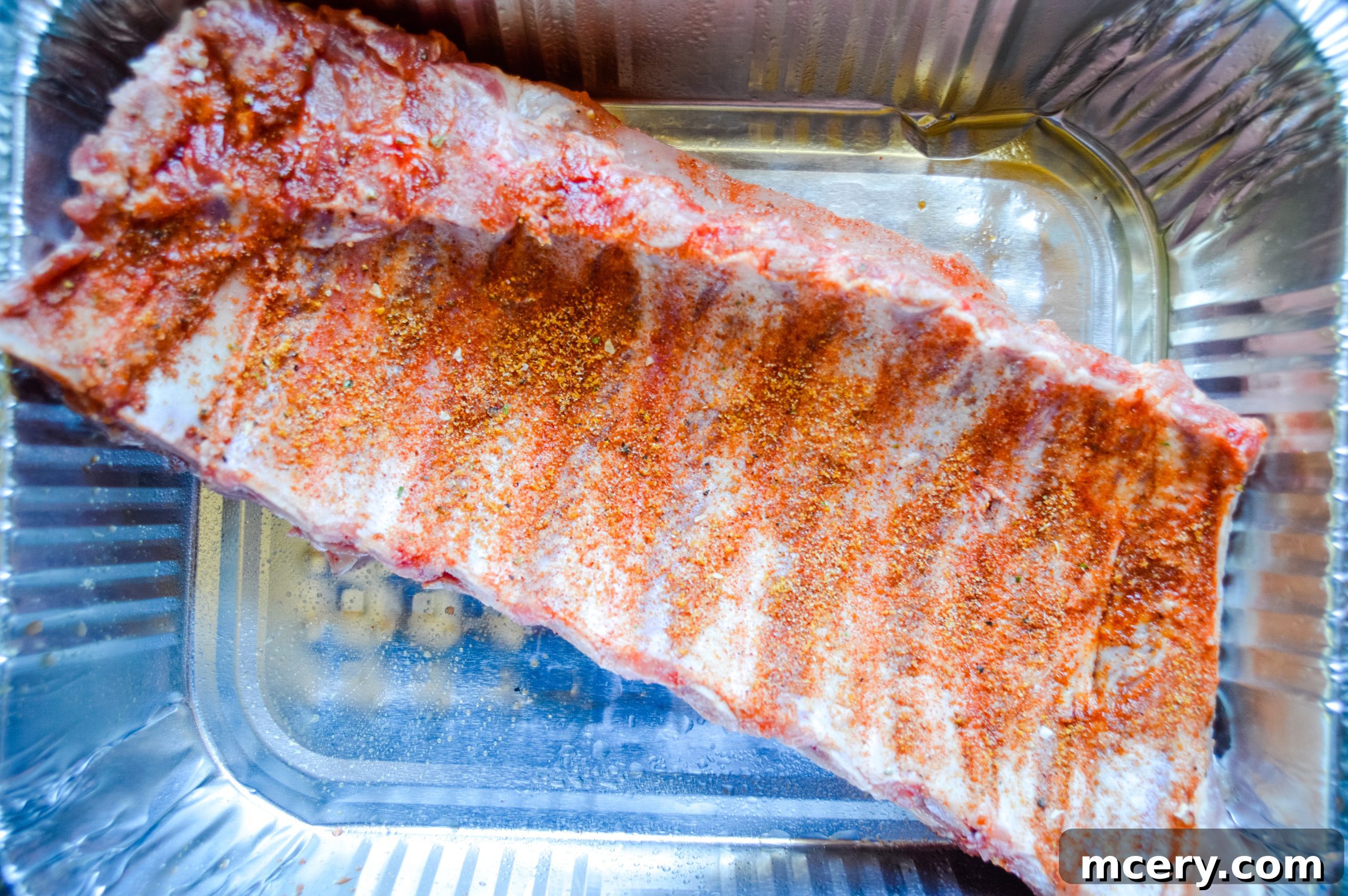Paleo Rubbed Gas Grilled Pork Ribs 7 A rack of ribs being generously coated with dry rub spices.