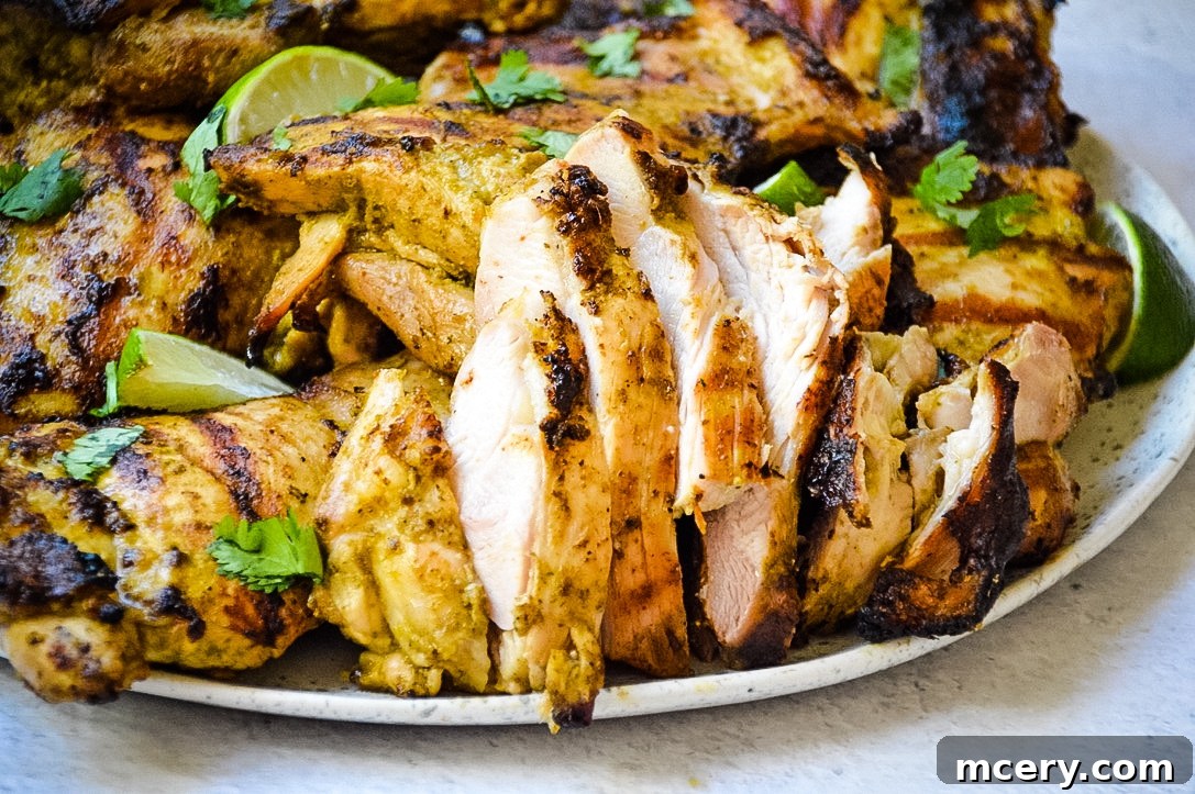 Marinated chicken thighs ready for grilling, showing a vibrant, zesty marinade coating.