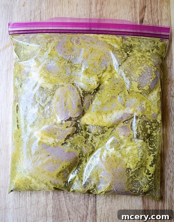 Chicken thighs in a large Ziploc bag with the green marinade poured over them.