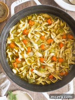 chicken noodle soup in a white pot.