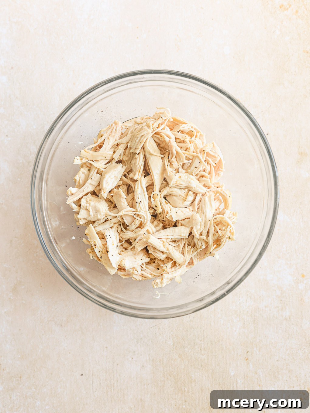 Cozy Homemade Chicken Noodle Soup 7 shredded chicken in a glass bowl.