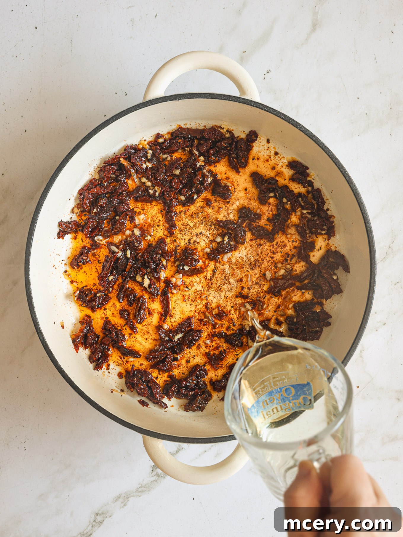 Your Guide to Perfect Marry Me Chicken 6 garlic and sun dried tomatoes in skillet.