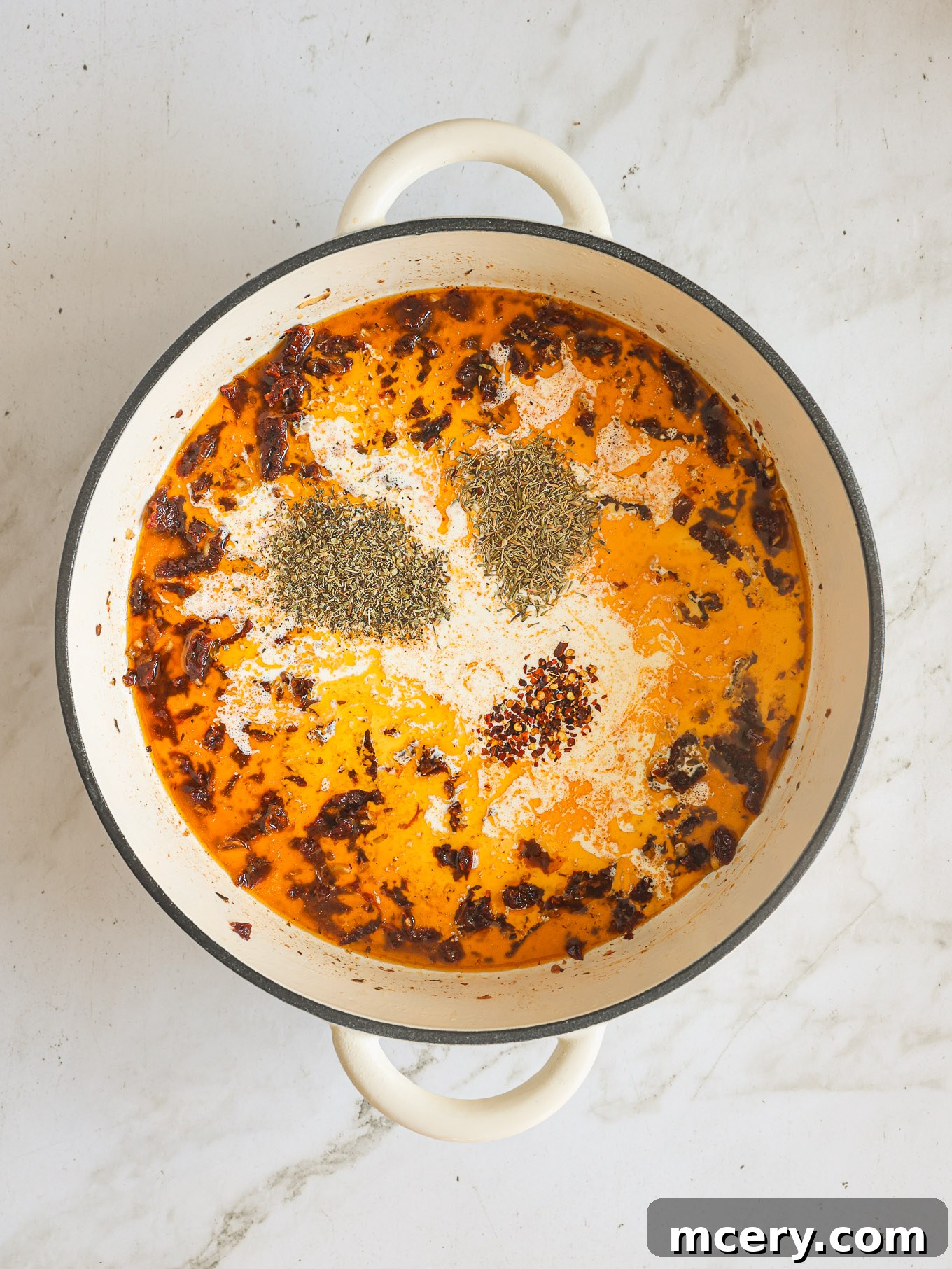Your Guide to Perfect Marry Me Chicken 7 sun dried tomato cream sauce in pan with spices.