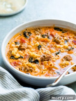 Italian sausage soup in a bowl with a spoon, ready to be served.