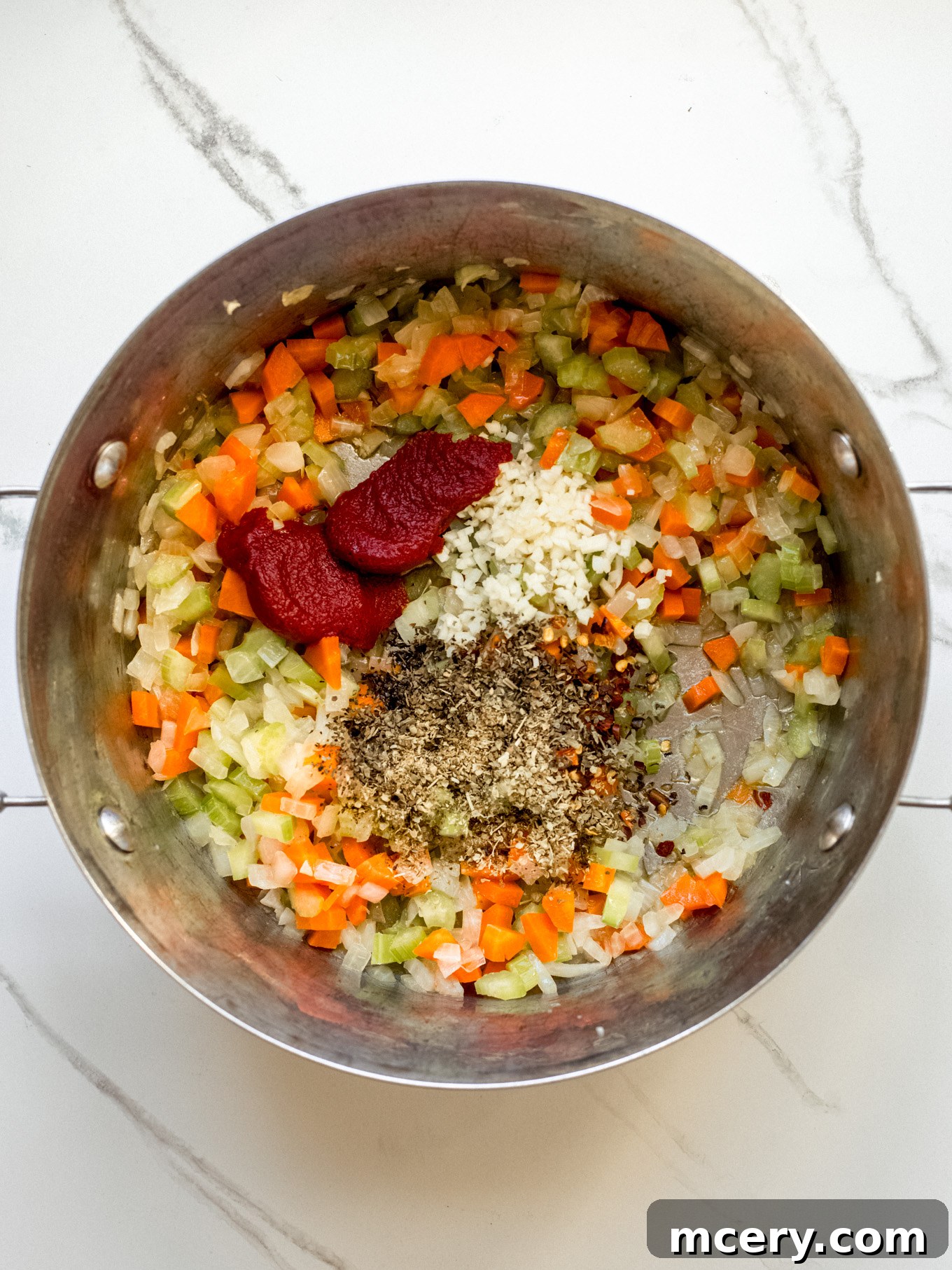 Hearty Italian Sausage Soup 5 Diced vegetables and spices sautéing in a pot with sausage drippings.