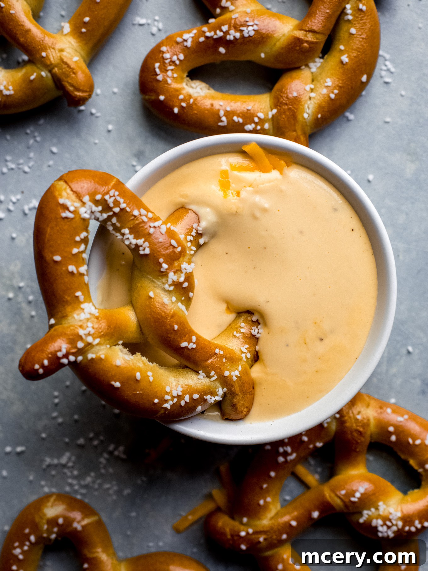 Velvety Smooth Cheese Sauce 2 A golden-brown pretzel perfectly dunked into a bowl of rich, creamy homemade cheese sauce.