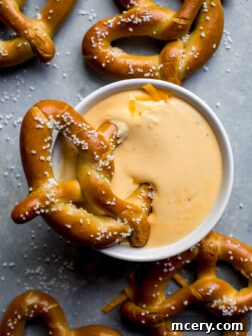 pretzel dunked into cheese sauce.