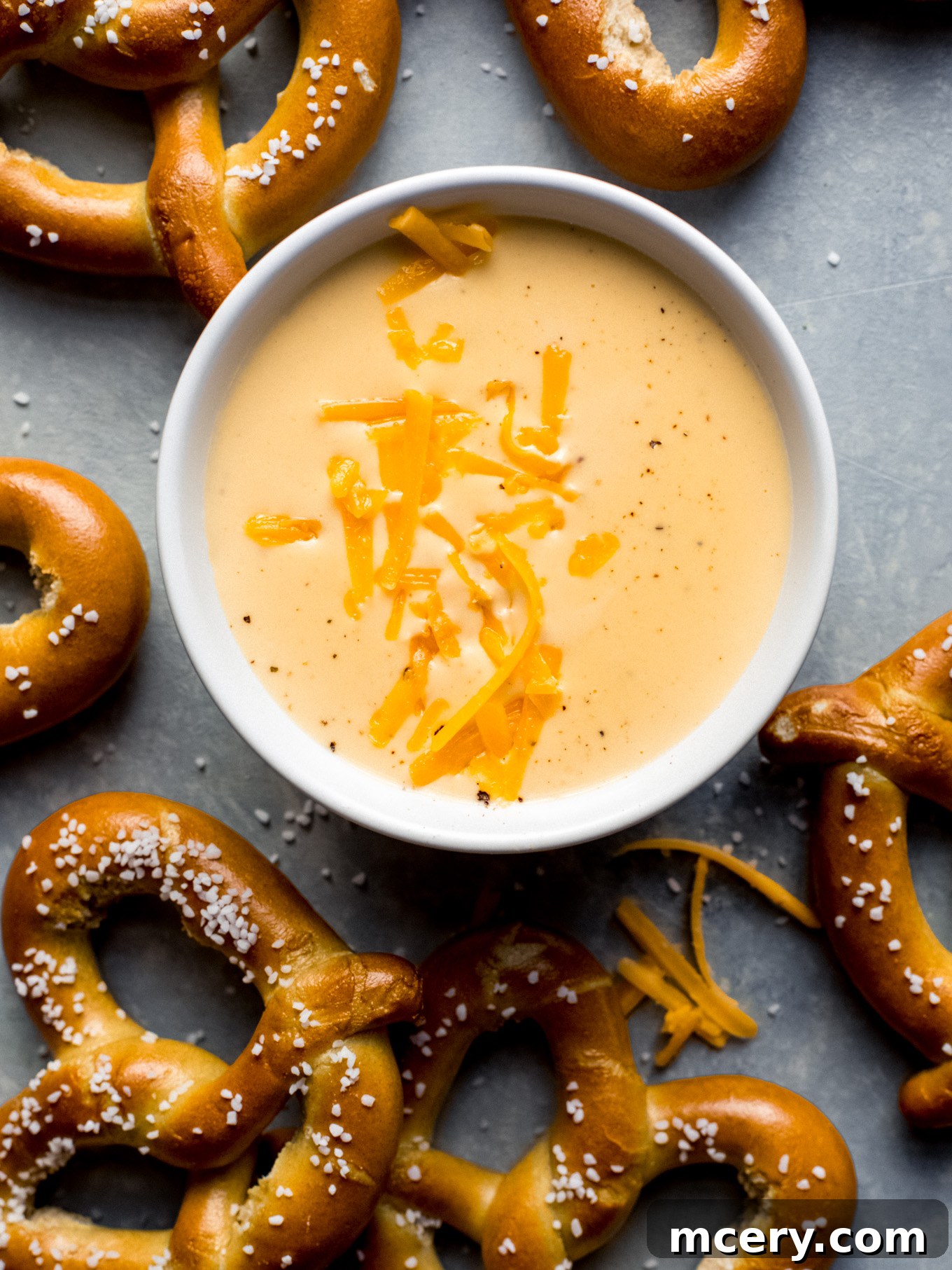 Velvety Smooth Cheese Sauce 8 A perfectly smooth, rich cheese sauce in a white bowl, ready for dipping, garnished with a sprinkle of fresh herbs.