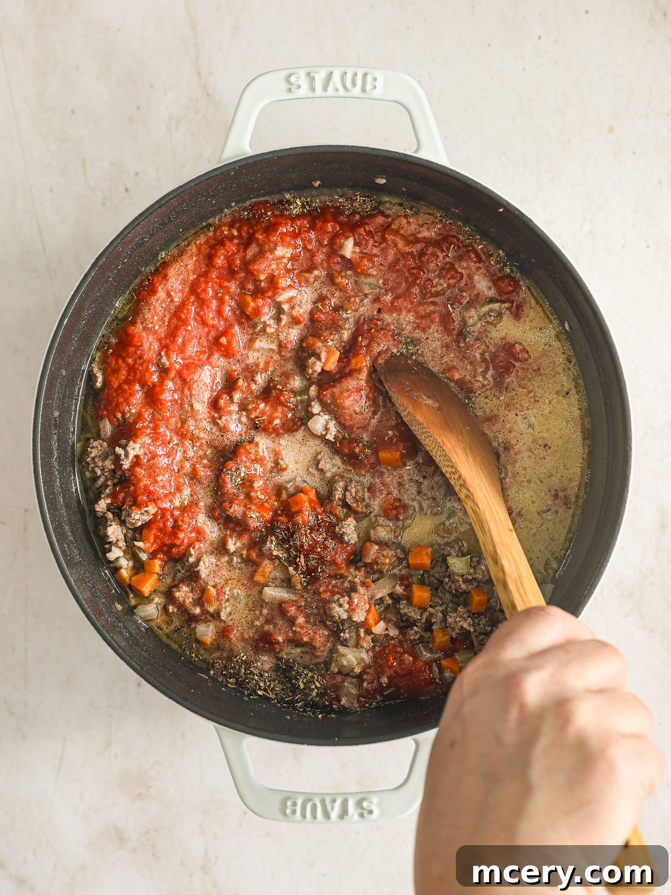Classic Hearty Bolognese Pasta 9 meat sauce in dutch oven with wooden spoon.