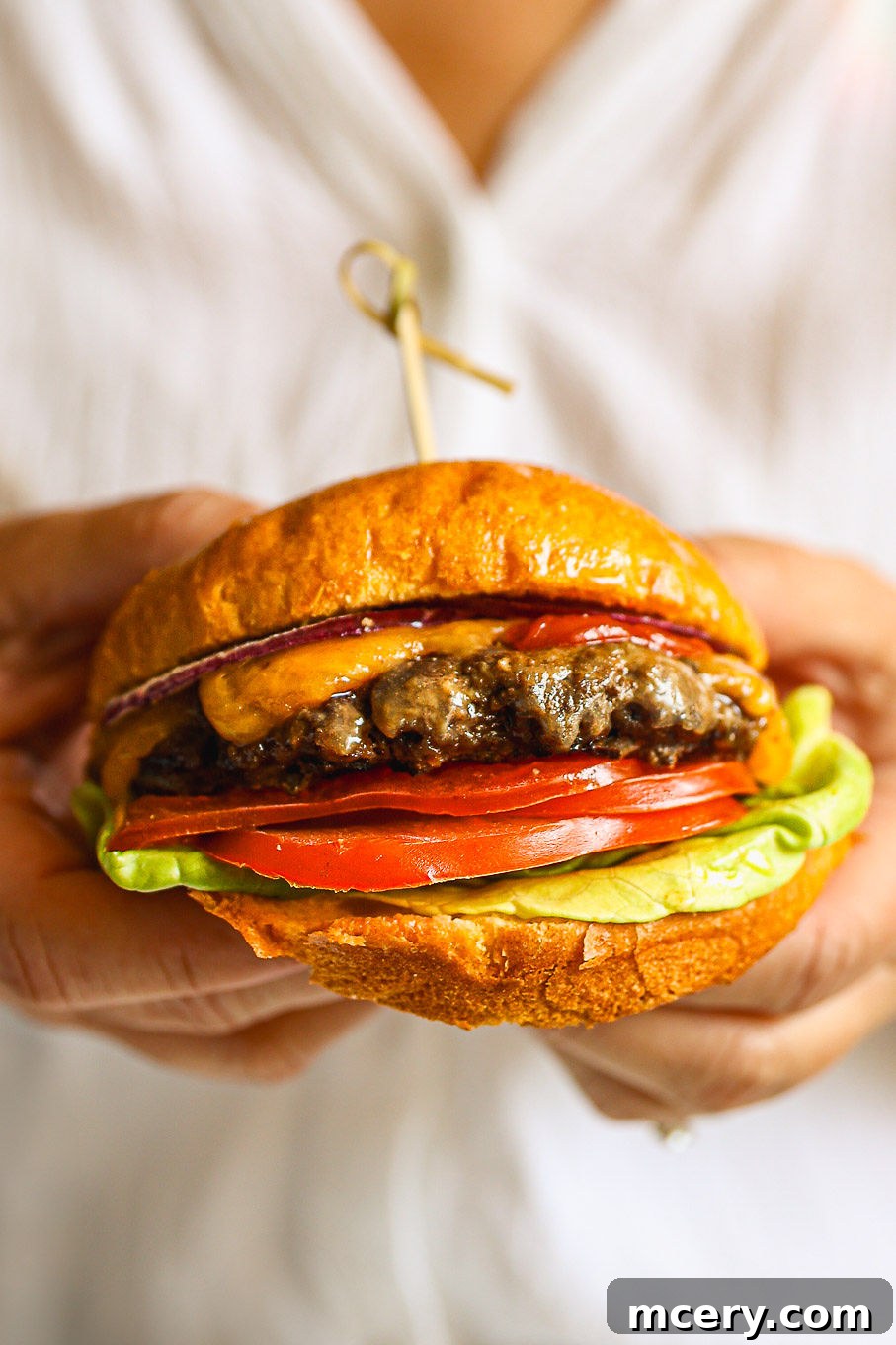 Crafting the Ultimate Homemade Burger 2 Close-up of a perfectly grilled beef burger patty with melted cheese and fresh toppings, nestled in a soft bun.