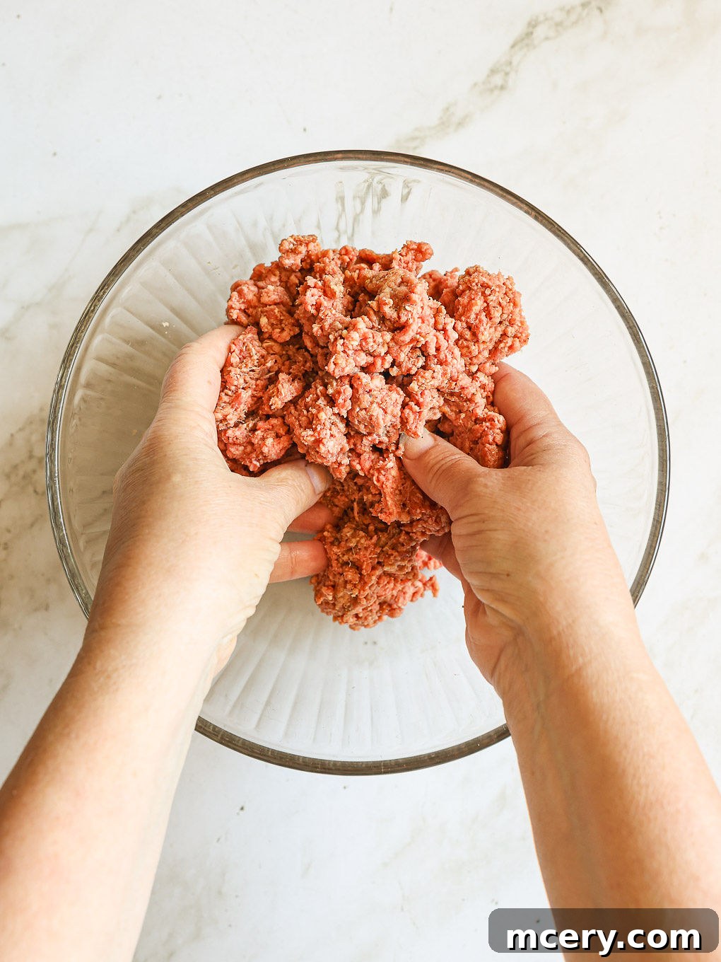 Crafting the Ultimate Homemade Burger 5 Hands gently mixing ground beef and spices in a bowl, demonstrating the proper technique to avoid overmixing.