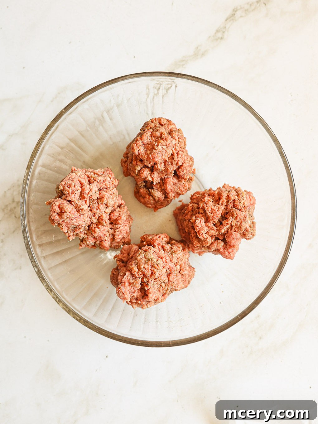 Crafting the Ultimate Homemade Burger 6 The beef mixture divided into four equal portions in a bowl, ready for shaping into patties.