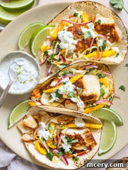 fish tacos topped with mango slaw on a platter.