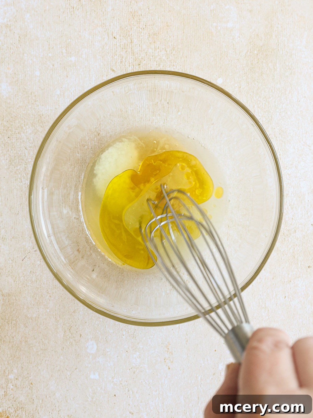 The Ultimate Homemade Fish Tacos 8 Ingredients for the mango slaw dressing being whisked in a small glass bowl.