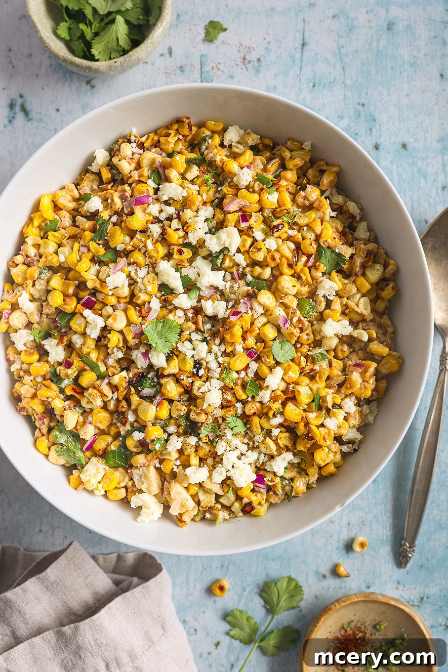 Delicious Mexican Corn Salad From Scratch 8 A close-up shot of a bowl of creamy Mexican corn salad, generously topped with crumbled Cotija cheese and fresh cilantro, highlighting its texture and freshness.