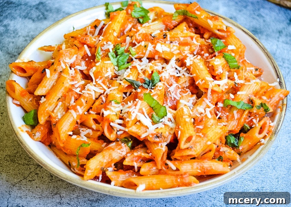 Close-up shot of raw San Marzano tomatoes in a can and fresh basil leaves, highlighting key ingredients for an authentic Penne Alla Vodka sauce.