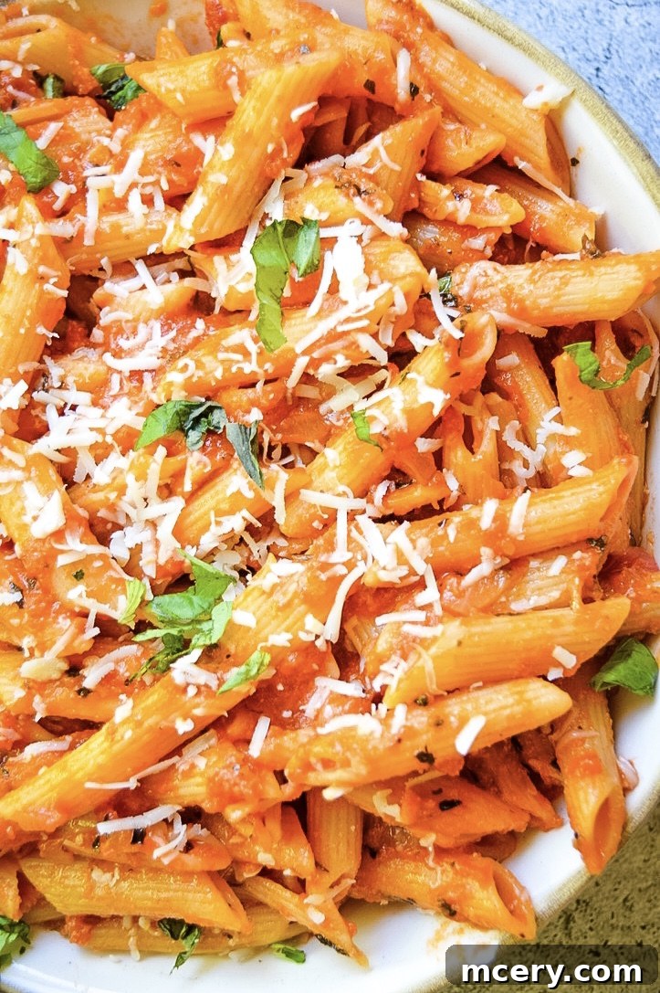 Penne Alla Vodka garnished with fresh basil leaves.