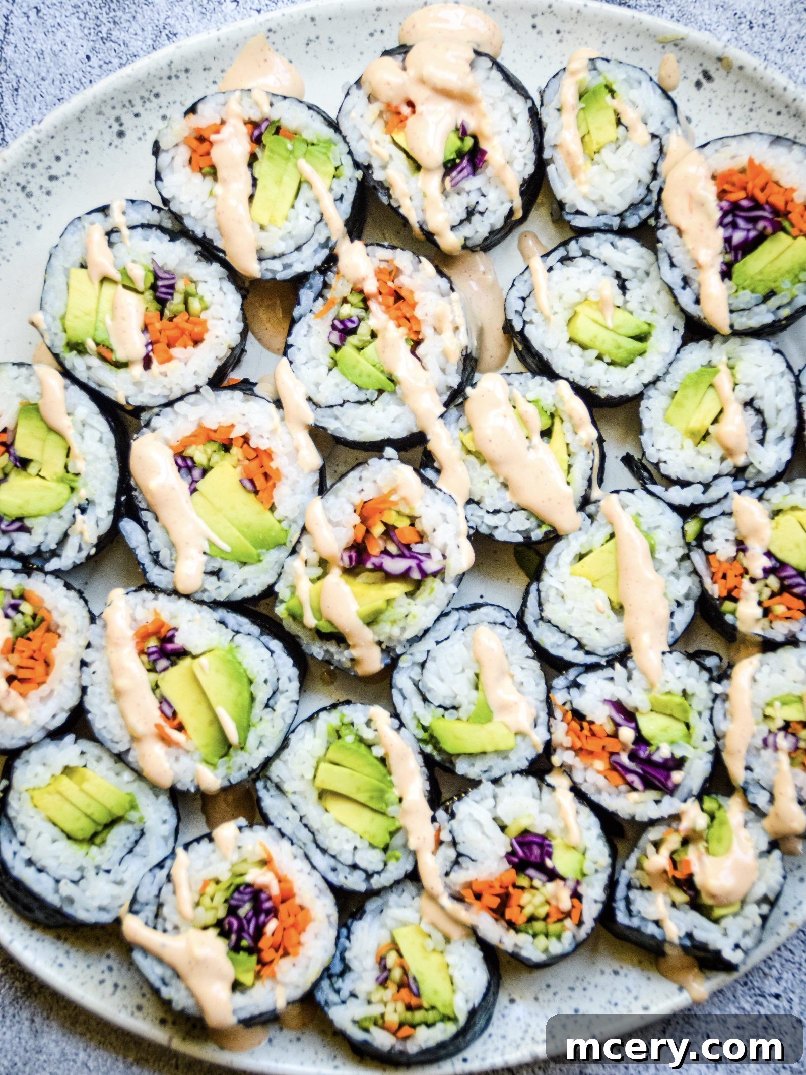 Kaleidoscope Sushi Rolls 3 A close-up of Rainbow Veggie Sushi Rolls, highlighting the fresh cucumber, avocado, and purple cabbage.