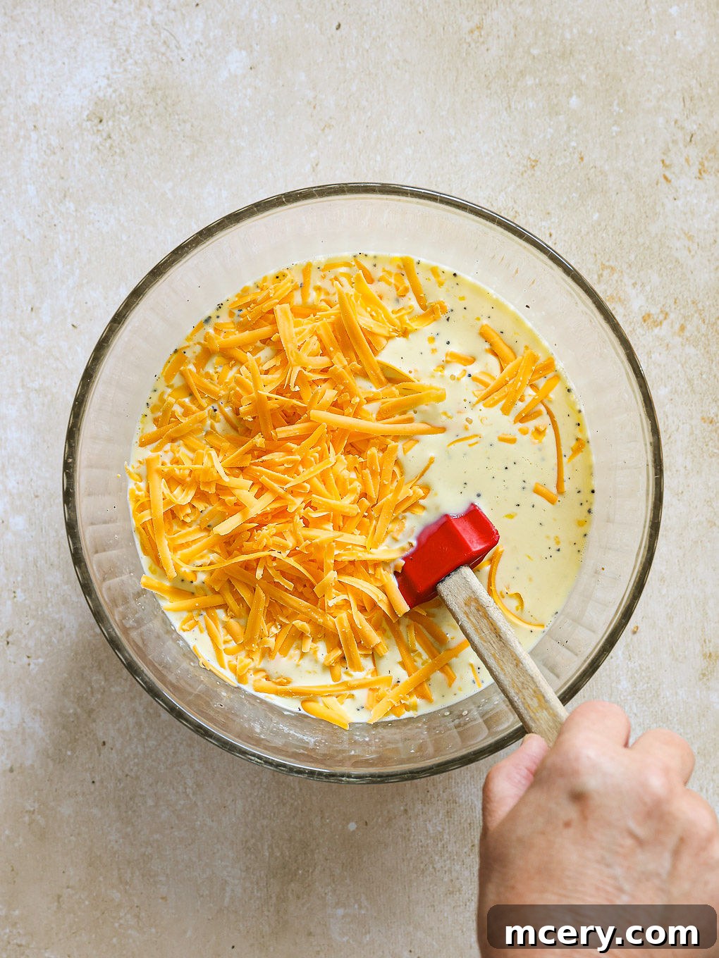 Overnight Southwest Fiesta Bake 7 shredded cheese being stirred into the egg mixture.
