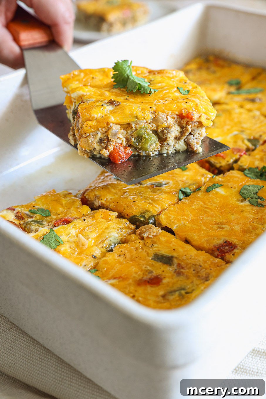 Overnight Southwest Fiesta Bake 10 side view of baked egg casserole in a white baking dish, ready to be served.