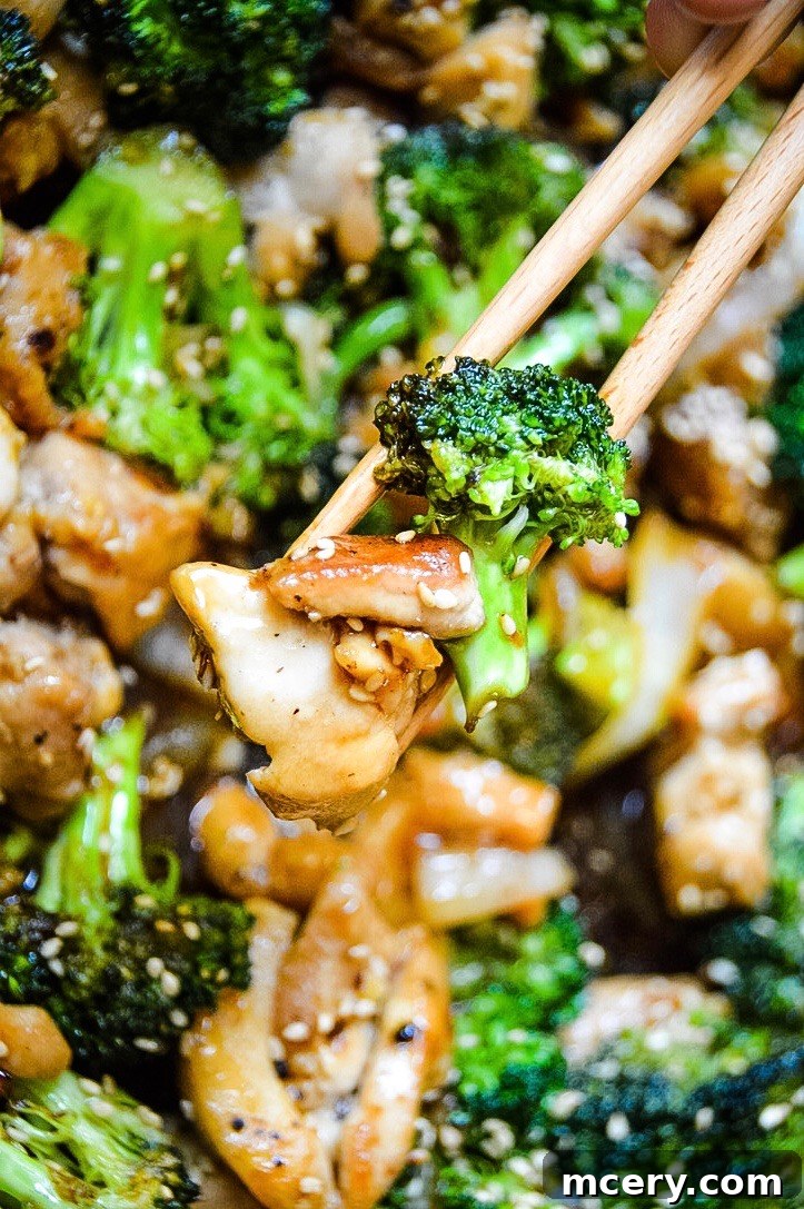 Savory Chicken and Broccoli Stir-Fry 2 A top-down view of a vibrant Chicken and Broccoli Stir Fry in a skillet, showcasing golden-brown chicken pieces, bright green broccoli florets, and sliced onions bathed in a rich, glossy sauce. The dish is ready to be served, promising a quick and flavorful meal.