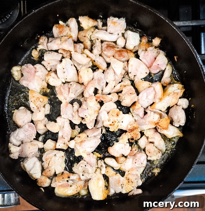 Savory Chicken and Broccoli Stir-Fry 4 A close-up of chicken pieces browning in a hot skillet with a clear oil sheen, showcasing the caramelization on the chicken. The cooking process is visible, emphasizing the importance of this step for flavor development.