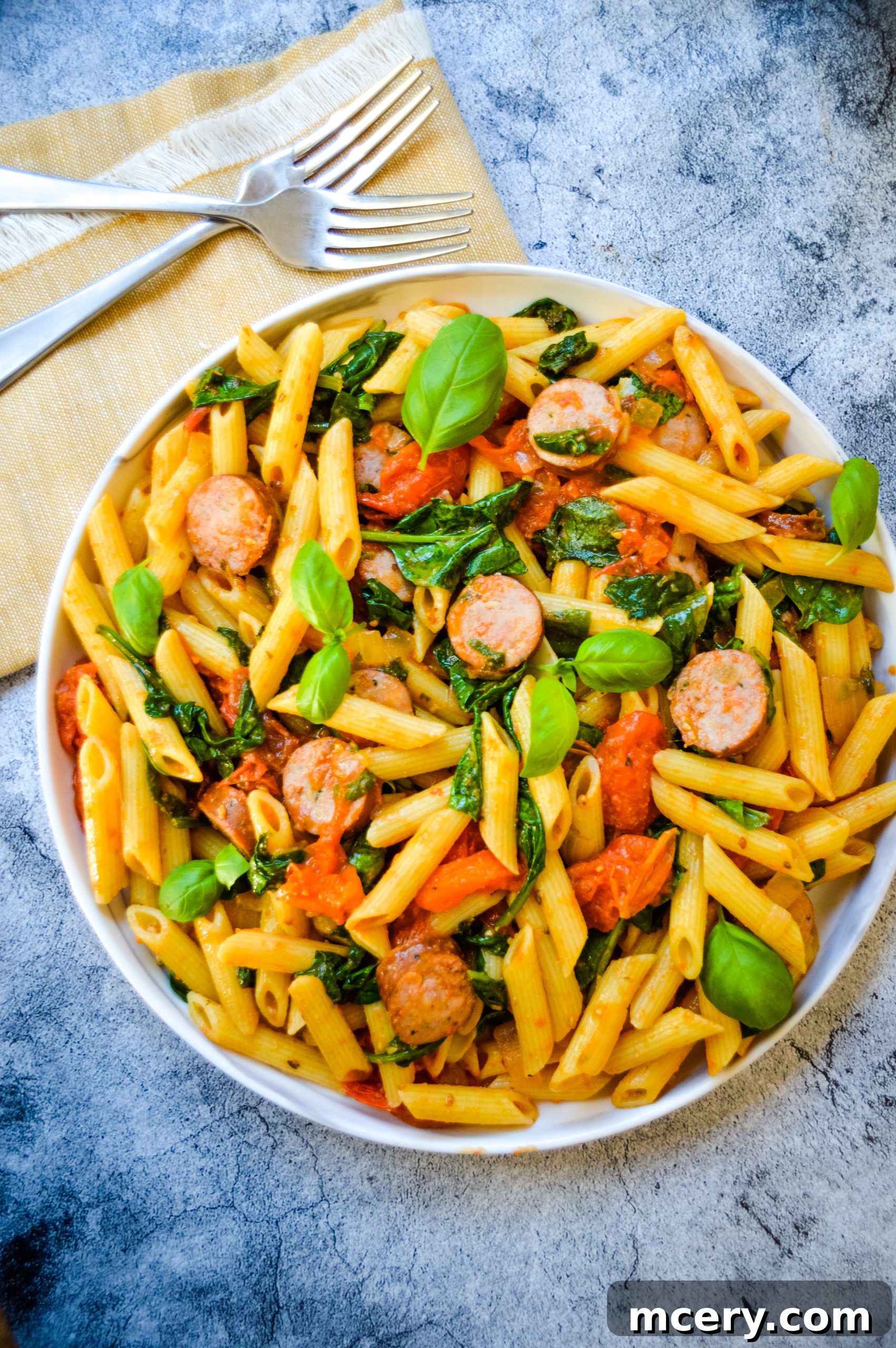Hearty Tomato Spinach and Sausage Pasta 2 A beautifully presented bowl of Easy Tomato Spinach and Sausage Pasta, garnished with fresh basil, ready to be enjoyed.