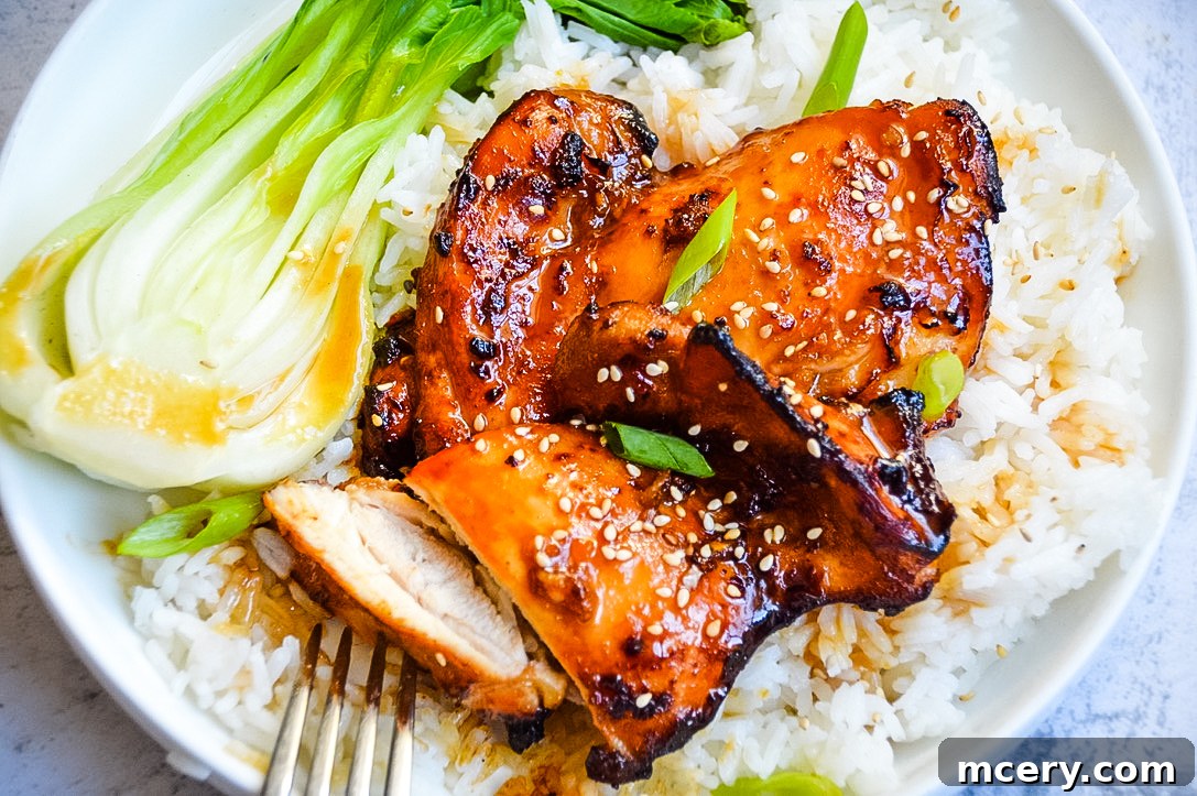 Sticky Soy Chicken Thighs 3 Close-up of three Asian Glazed Chicken Thighs marinating in a rich, dark sauce within a bowl, ready for cooking.