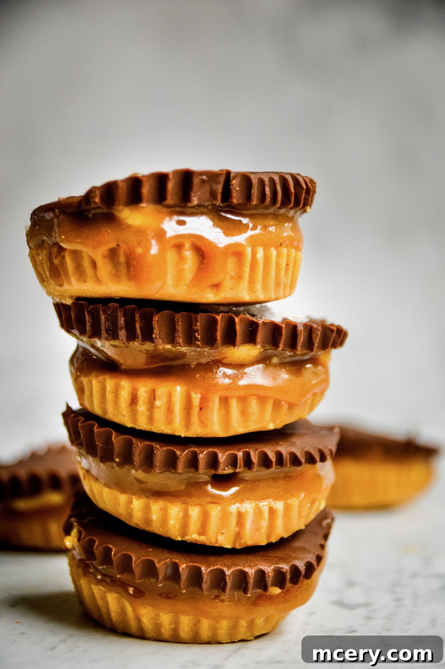 Irresistible Vegan Peanut Butter Caramel Cups 3 Close-up shot of a Vegan Peanut Butter Caramel Cup, highlighting the smooth chocolate top and the visible caramel layer within.