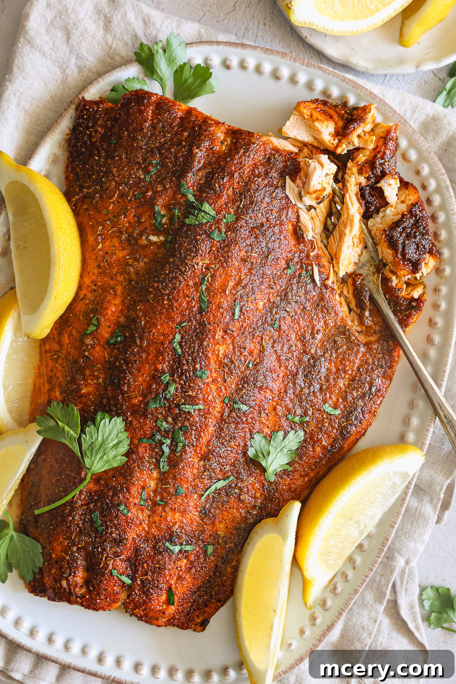 Unlock the Flavor Mastering Blackened Salmon 2 Perfectly cooked blackened salmon fillets garnished with fresh lemon wedges, ready to serve.