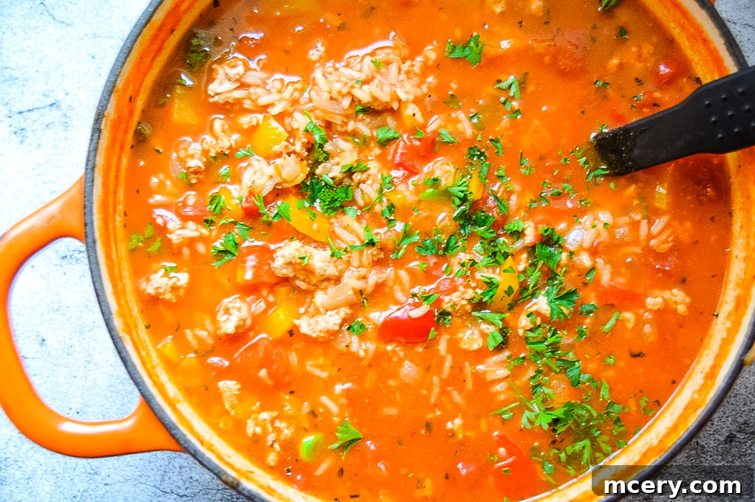 Savory Stuffed Bell Pepper Pot 4 A vibrant bowl of Stuffed Pepper Soup, showcasing chunks of bell peppers, ground meat, and rice in a rich tomato base.
