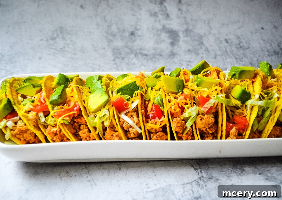 Easy Instant Pot Ground Turkey Tacos 5 A close-up shot of a single Instant Pot Ground Turkey Taco held in hand, showcasing the crispy shell overflowing with seasoned ground turkey, shredded cheese, and fresh lettuce. The focus is on the delicious texture and vibrant colors.