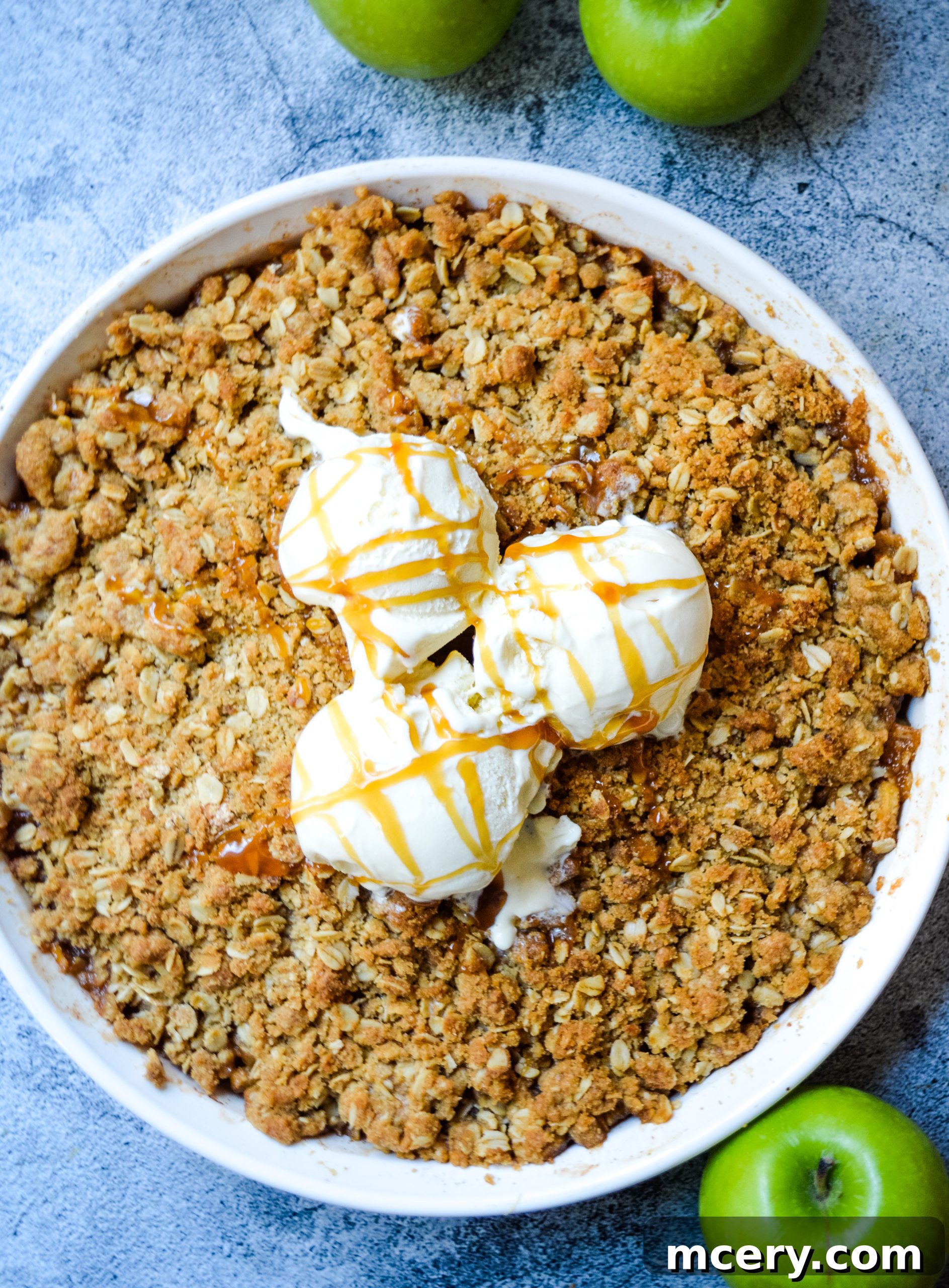 Ingredients for apple crisp laid out: sliced green apples, agave, cinnamon, lemon juice, brown sugar, oats, flour, butter, and salt.