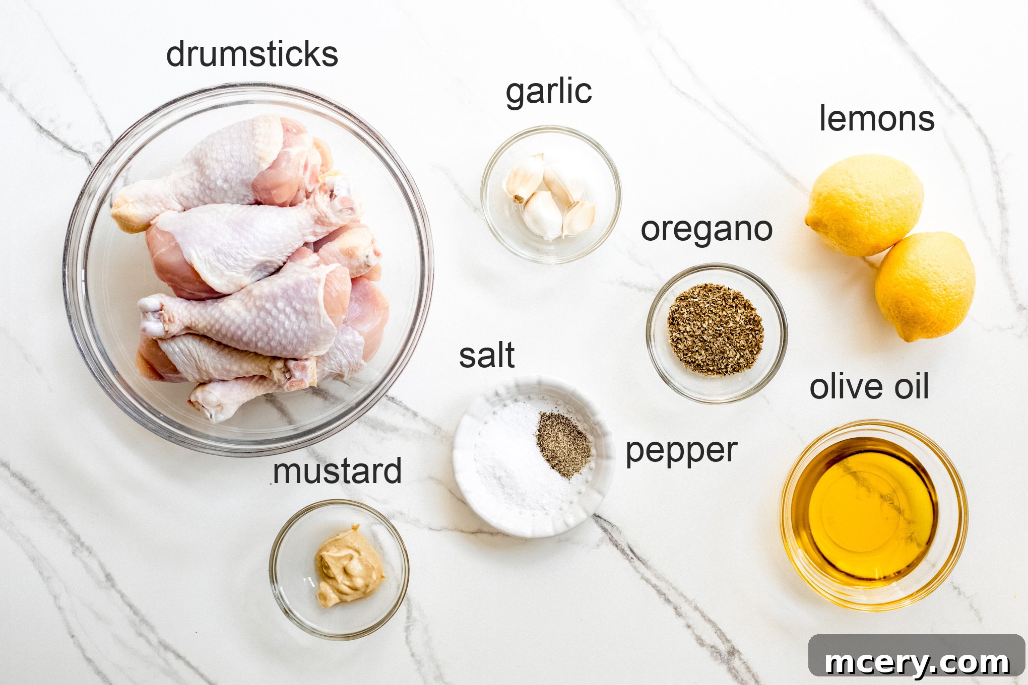 Smoky Grilled Chicken Drumsticks 3 A flat lay photograph showcasing all the fresh ingredients needed for the grilled chicken legs recipe, including lemons, garlic, fresh oregano, and drumsticks.