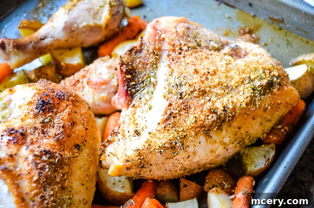Effortless Sheet Pan Chicken and Potatoes 2 A vibrant platter of one-pan roasted chicken and potatoes, featuring perfectly golden-brown chicken pieces and crispy roasted potatoes. Fresh herbs garnish the dish, adding a pop of color and freshness. The meal is presented on a rustic wooden board, emphasizing its homemade appeal.