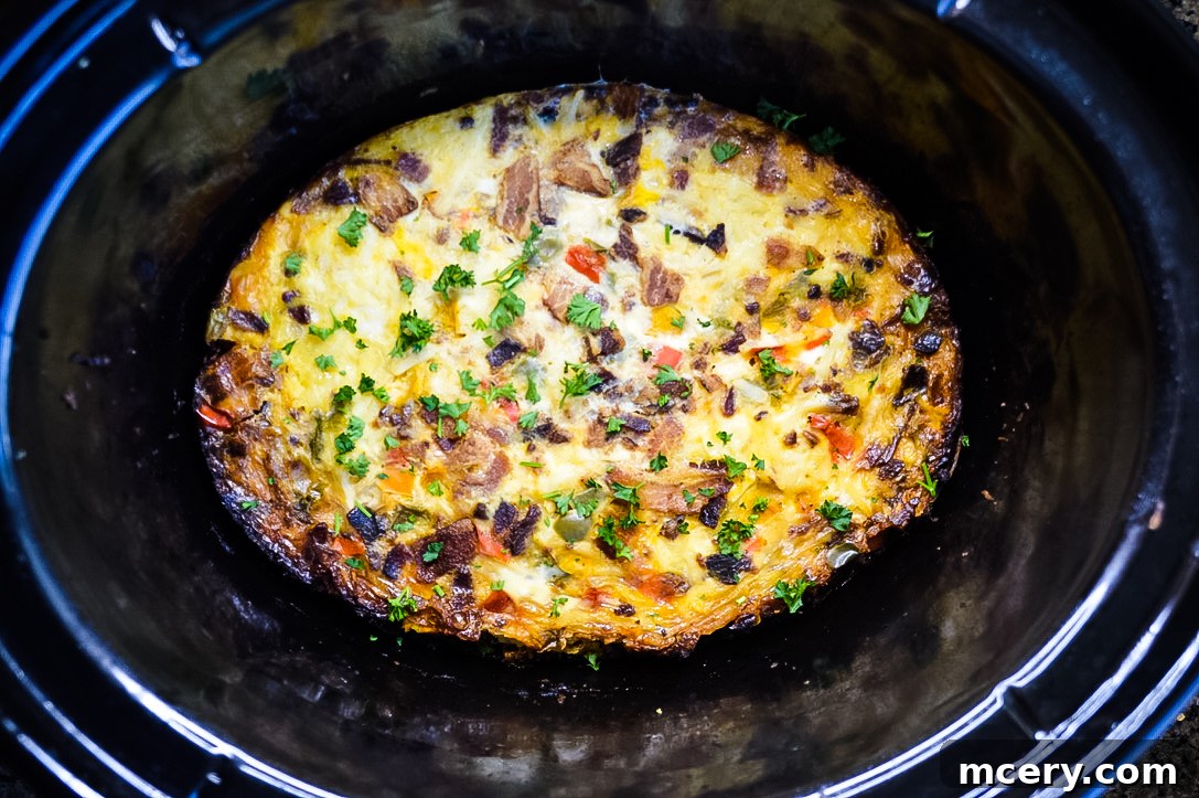 Slow Cooker Sunrise Casserole 5 CrockPot Breakfast Casserole inside a slow cooker, cooked to golden perfection and garnished with herbs