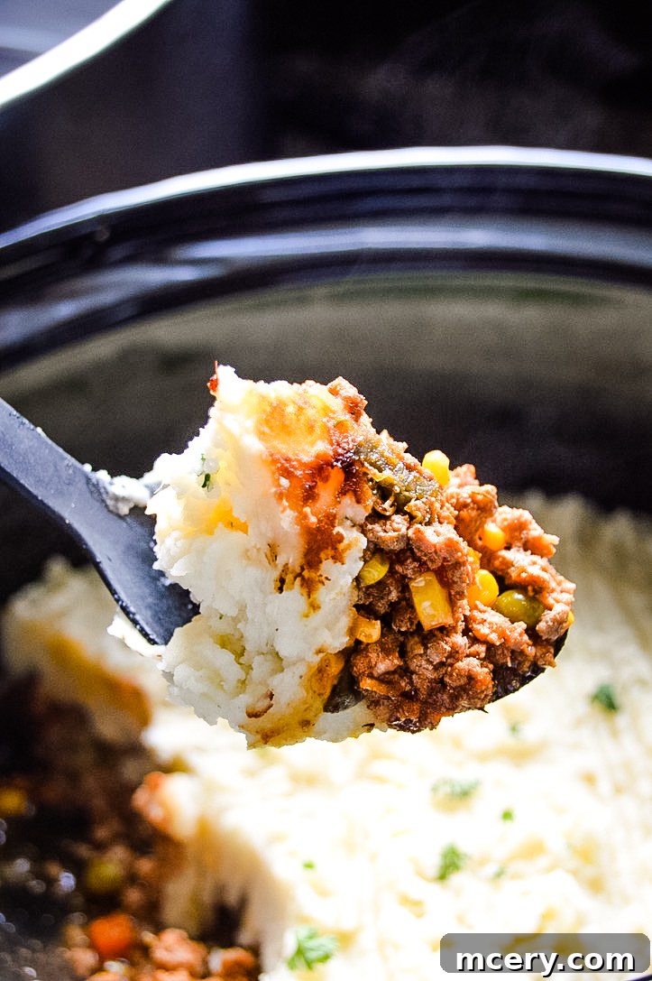 Hearty Slow Cooker Shepherds Pie 4 A single serving of Crockpot Shepherd's Pie in a white bowl, showing the layers of mashed potatoes, ground turkey, and mixed vegetables.
