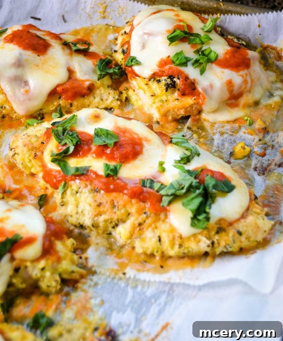 A beautifully plated slice of Keto Baked Chicken Parmesan, showing a golden crispy crust, melted cheese, and rich marinara sauce.
