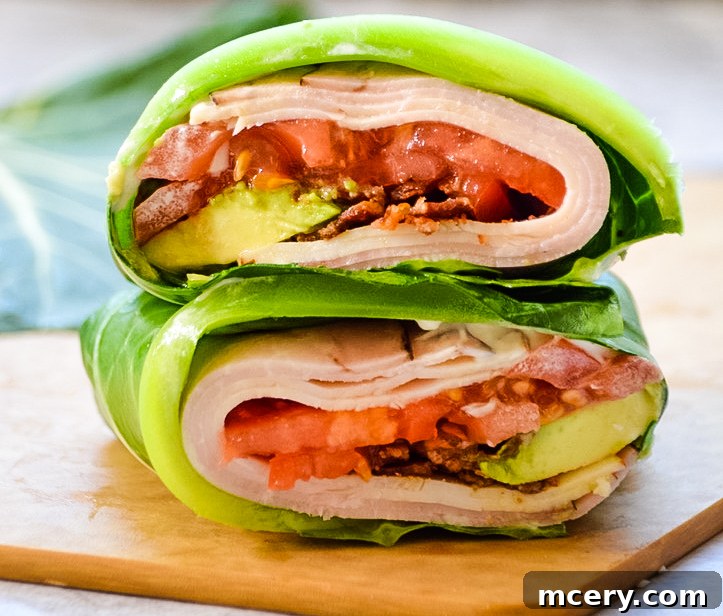 Golden State Collard Sandwich 2 Two California Collard Subs with a fresh green collard leaf wrapper, showing slices of turkey, avocado, and tomato filling on a rustic wooden board.