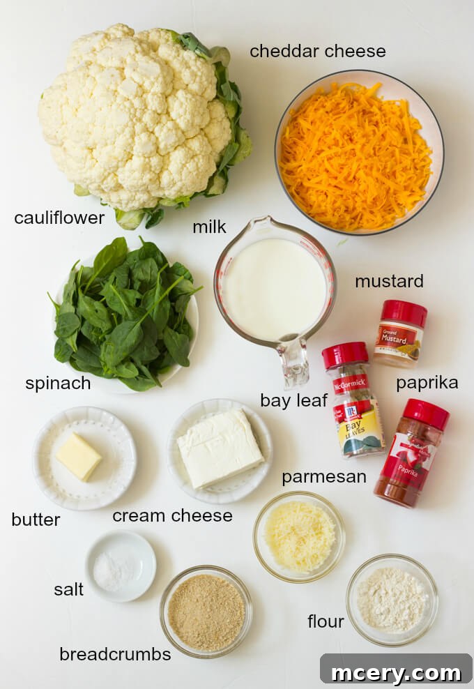 Ingredients for cauliflower spinach recipes laid out on a wooden surface.