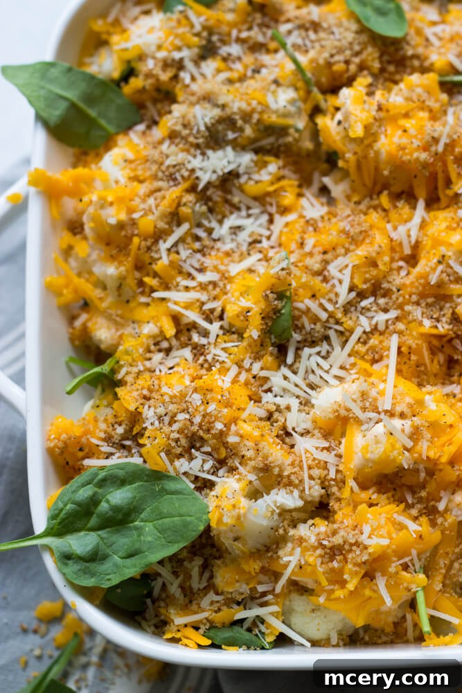 Overhead shot of cauliflower and spinach in a creamy cheese sauce, topped with breadcrumbs and cheese.