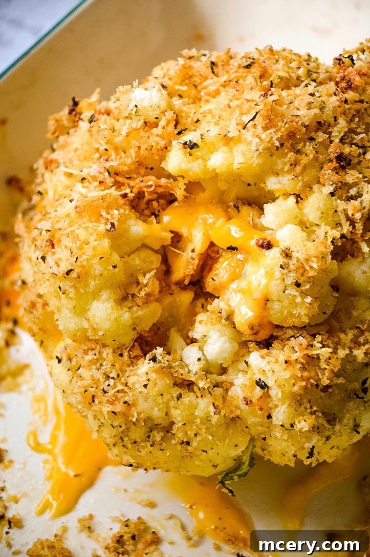 Golden Cheddar Stuffed Cauliflower 3 A close-up view of the baked cauliflower, showing the rich, melted cheddar cheese peeking through the golden brown Panko breadcrumbs, ready to be served.